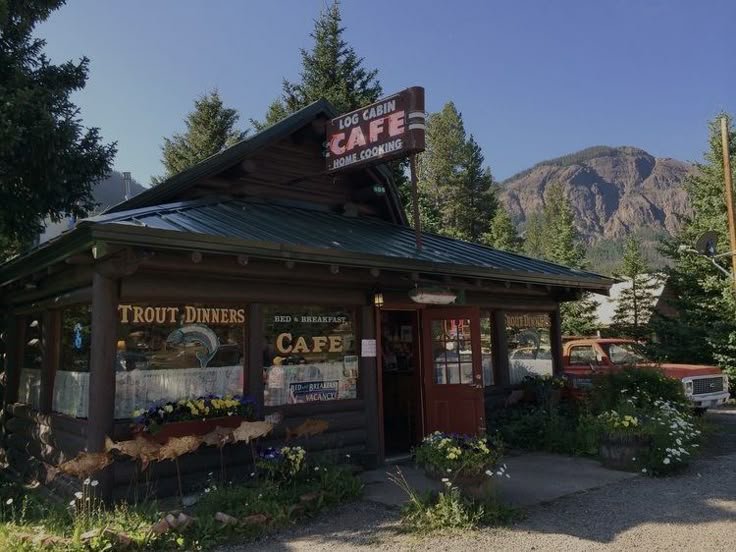 the front of a restaurant with mountains in the background