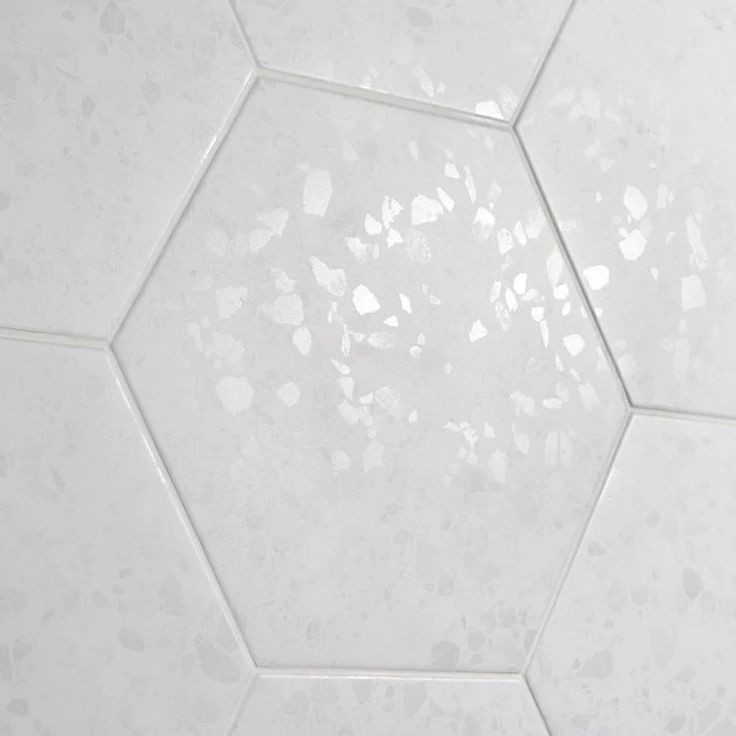 a white hexagonal tile floor with small holes in it