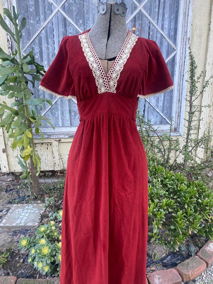 Vintage 1970s maxi length dress, in a red/orange velvet material. The fabric picks up as a more solid red in lowlight and indoor lighting and in direct sunlight shows as more of an orange red/ carnelian (shown in last two photos, no filter). This dress features a lace trim around the neckline as well as a empire waist line that sits under the bust with a tie in the back to customize the fit. The sleeves are oversized and provide a nice flowy look as well as having a matching lace trim. Metal zip Red Prairie Dress, Vintage Red Dress With Lace Trim, Red Vintage Dress With Lace Trim, Red Vintage Floor-length Dress, 1970s Fashion Women Dresses, 1970s Fashion Women, Dressing Ideas, Dress With Lace Trim, Red Carnelian