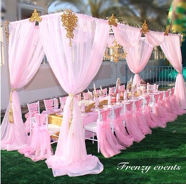 a pink wedding set up with chairs and tables