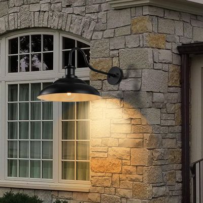 an outdoor light on the side of a brick building next to a door and window