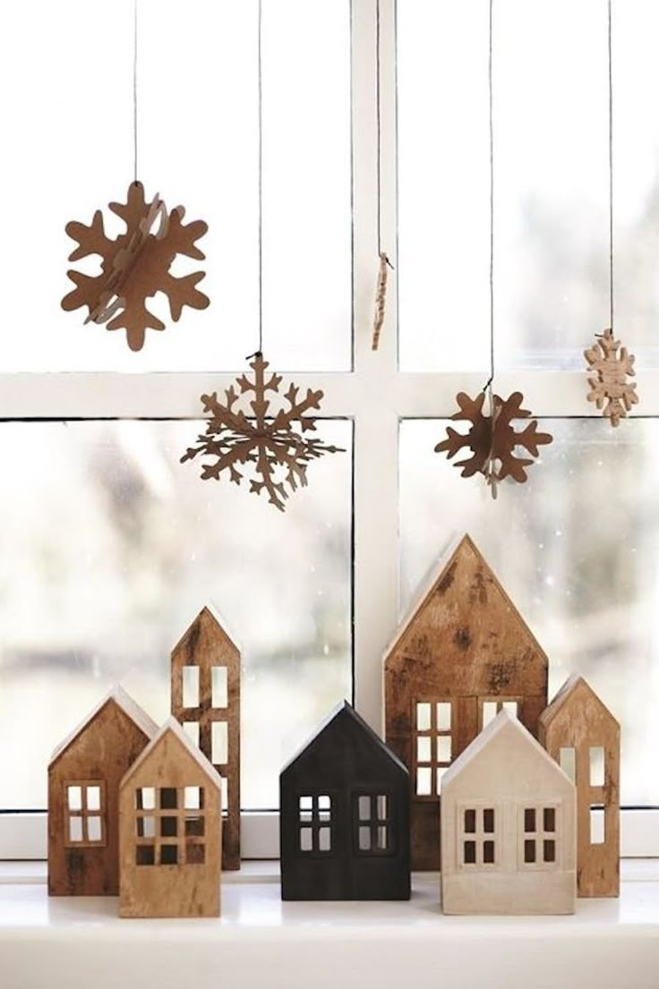 wooden houses and snowflakes hanging from a window