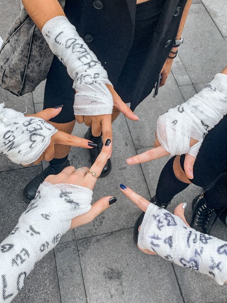 several people with their hands wrapped in bandages pointing at the camera while standing on a sidewalk