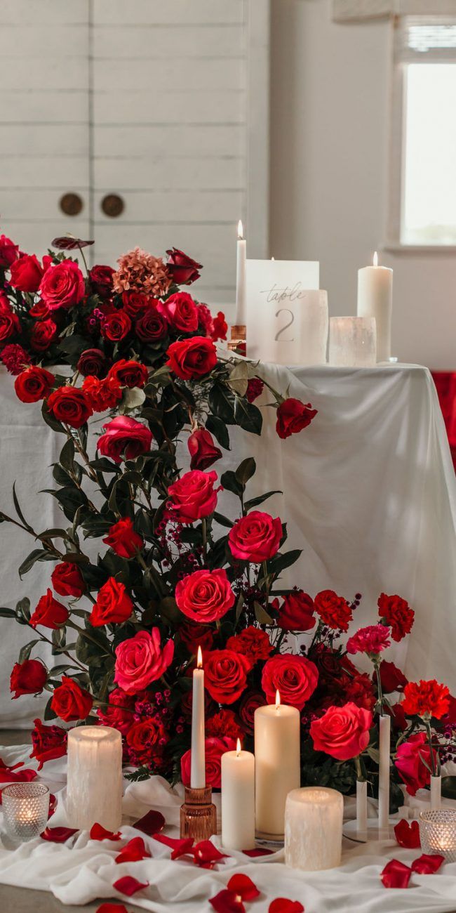 a table topped with candles and red roses