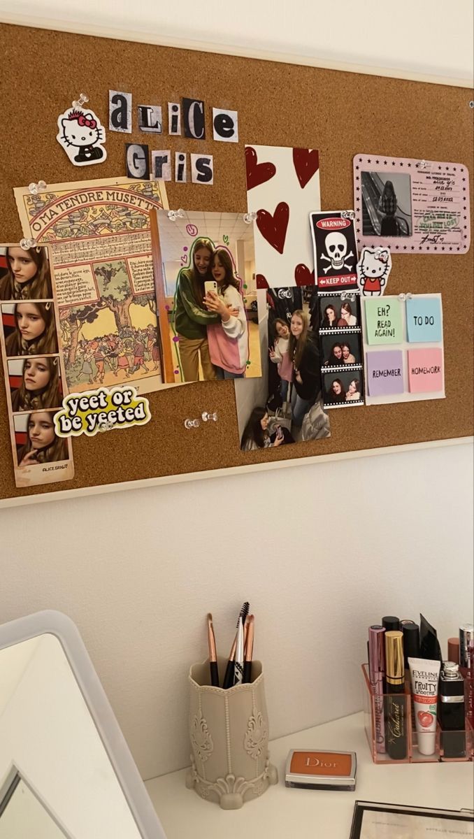 a bulletin board with pictures and magnets attached to it on the wall next to a desk