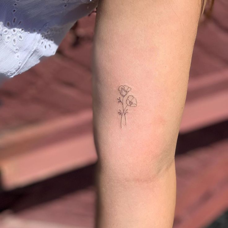 a small flower tattoo on the leg