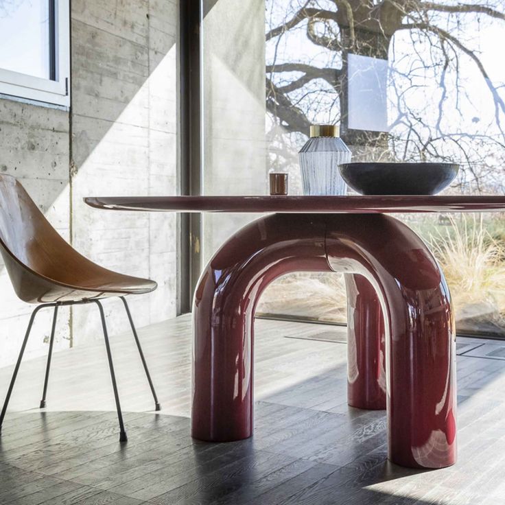 a dining table with two chairs and a bowl on top of it in front of a window