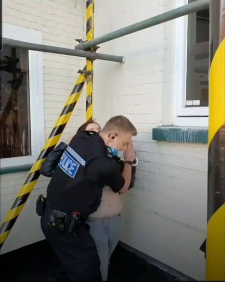 a police officer is helping a child on the back of a truck to get out of the house