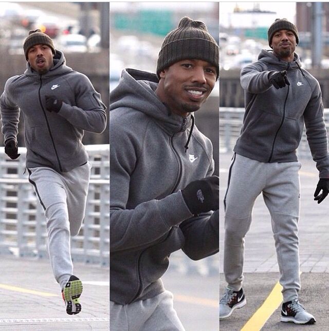 a man in grey sweat suit and hat running