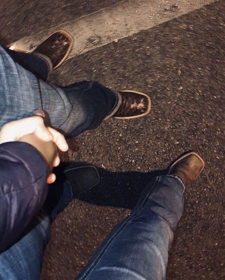 two people standing next to each other with their feet on the ground and one person holding something in his hand