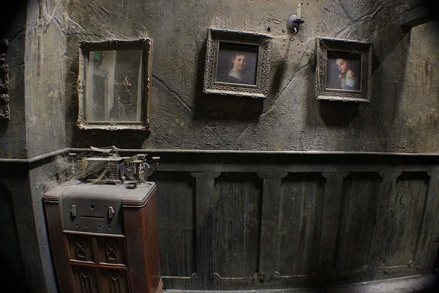 an old suitcase is sitting in the corner of a room with pictures on the wall