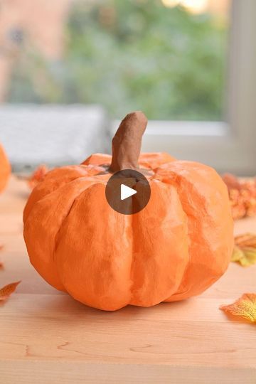 an orange pumpkin sitting on top of a wooden table