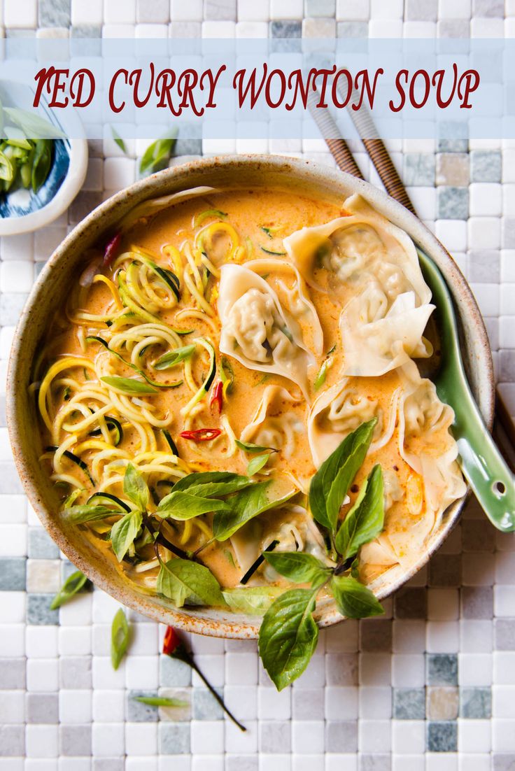 a bowl of red curry wonton soup with noodles and spinach on the side