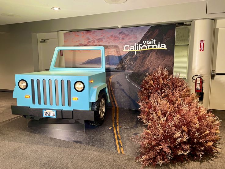 a blue jeep parked in front of a sign