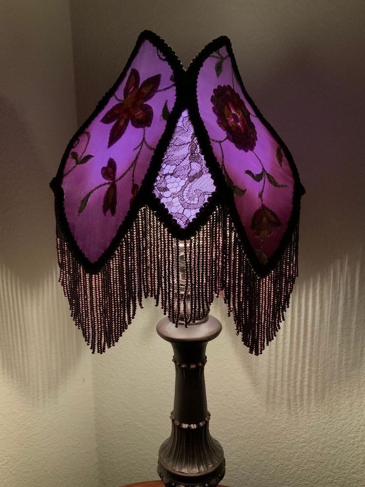 a table lamp with two purple lampshades on it