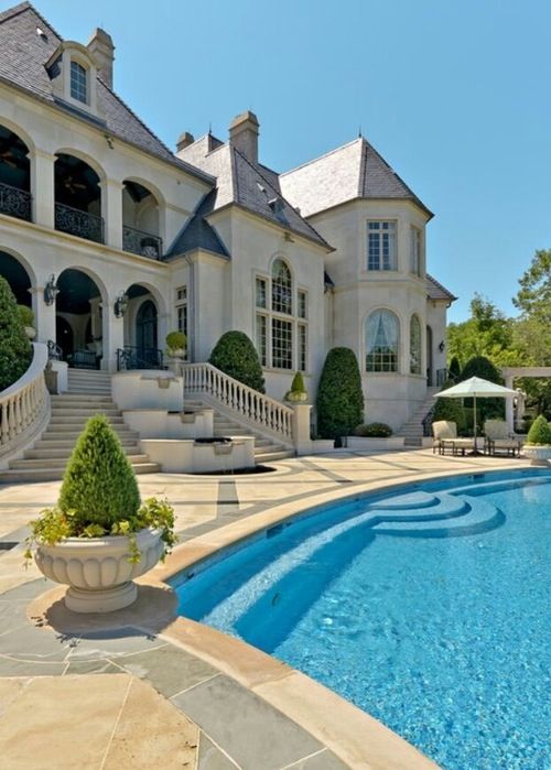 a large house with a swimming pool in the front yard and stairs leading up to it