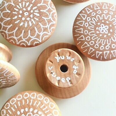 several wooden buttons with white designs on them