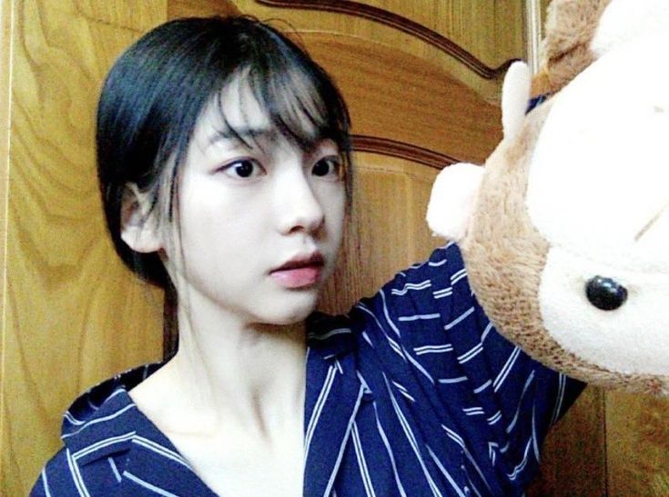 a woman holding up a teddy bear in front of her face