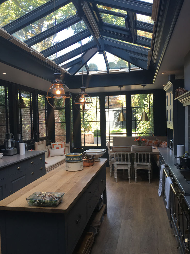 an open kitchen and dining room with skylights above the counter top, is shown in this image