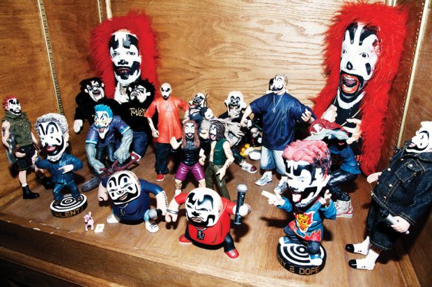 a group of toy clowns sitting on top of a wooden shelf next to each other