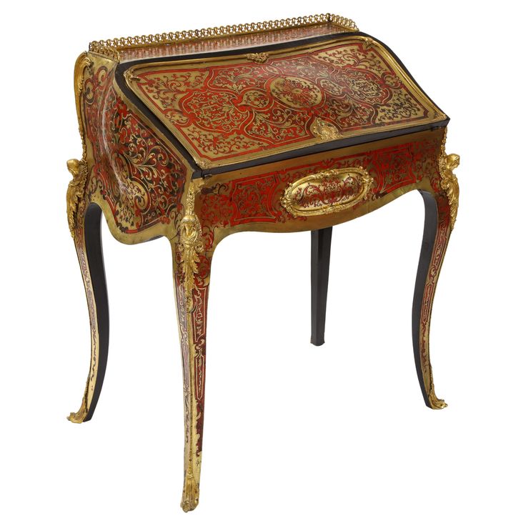 an ornately decorated table with gold trimmings and red paint on the top