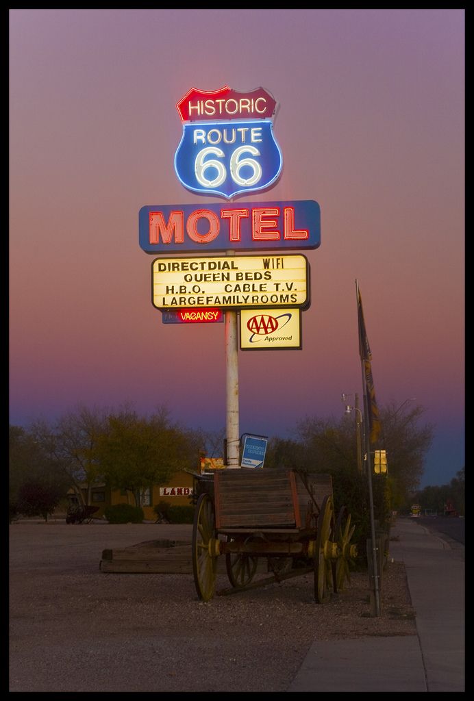 a motel sign with a wagon underneath it