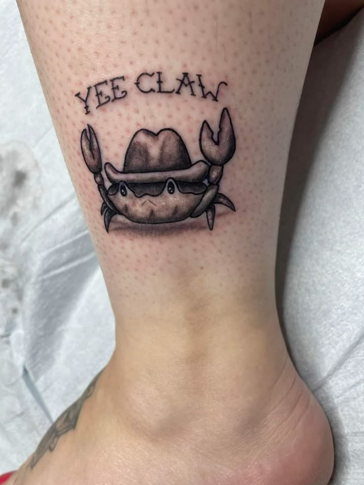 a crab with a hat on its head and the words yee claw written in black ink