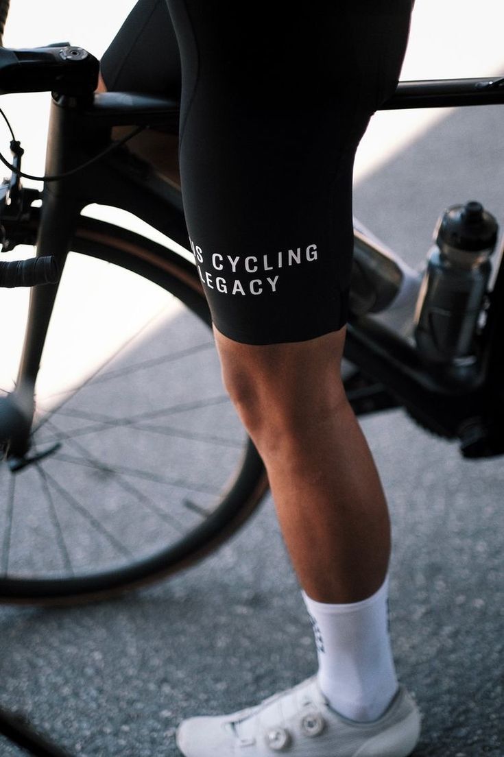 the legs and ankles of a person riding a bike wearing cycling shorts with white socks