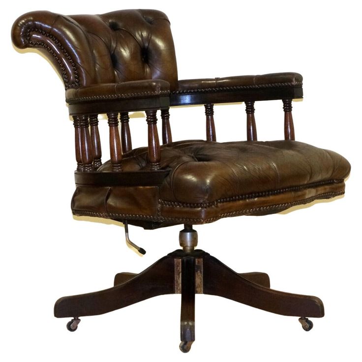 a brown leather office chair sitting on top of a wooden desk with casteor wheels