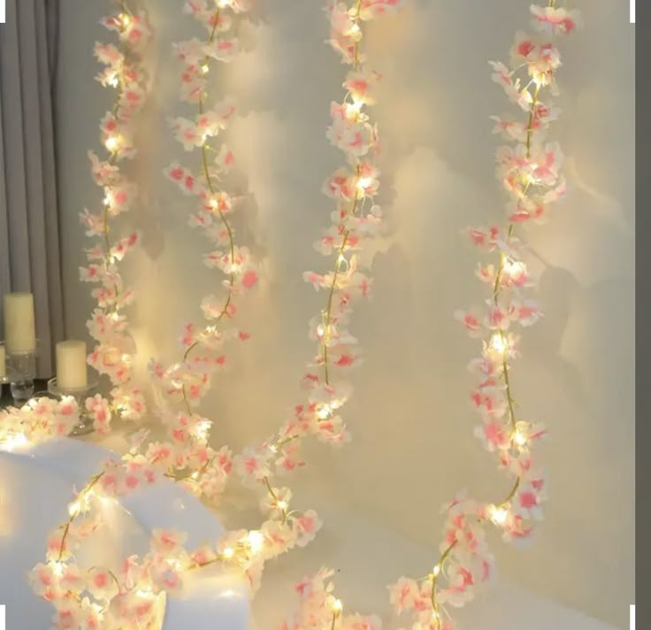 flowers and fairy lights are hanging from the wall