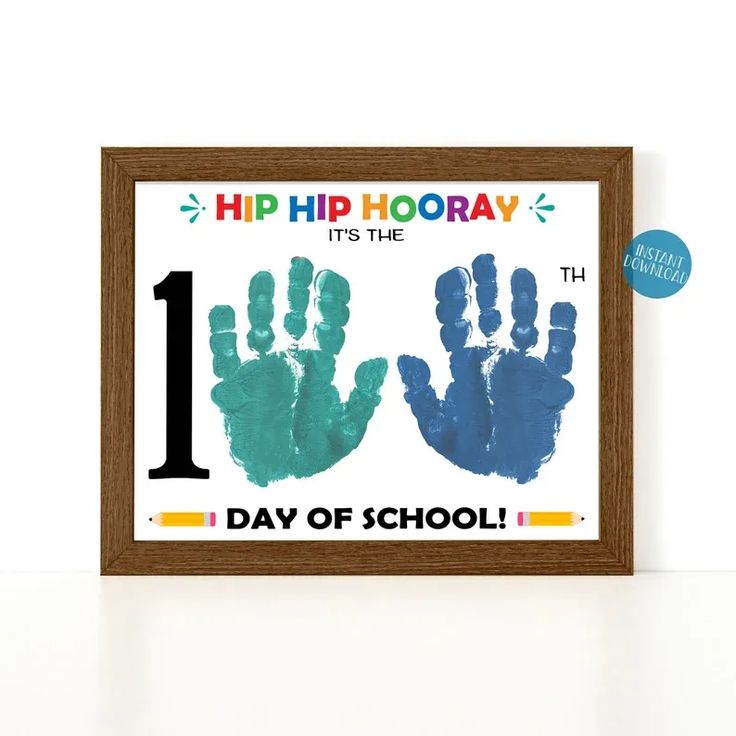 two handprints with the number one on them are displayed in front of a wooden frame