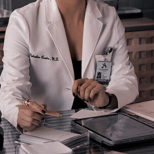 a woman in a lab coat sitting at a table