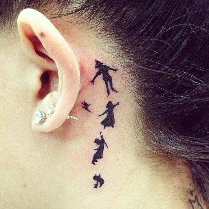 a woman's behind the ear tattoo with silhouettes of people flying in different directions