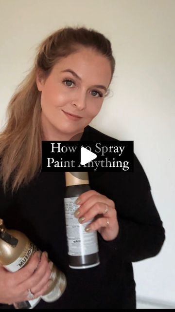 a woman is holding a spray bottle and smiling