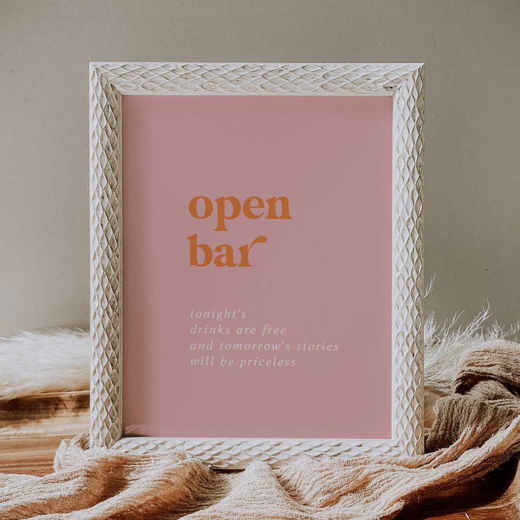 an open bar sign sitting on top of a table next to a pile of blankets