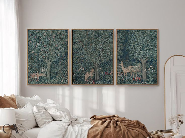 two paintings hanging on the wall above a bed