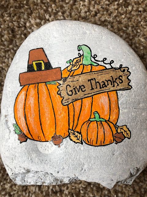 a painted rock that says give thanks with a pumpkin on it and a witch hat