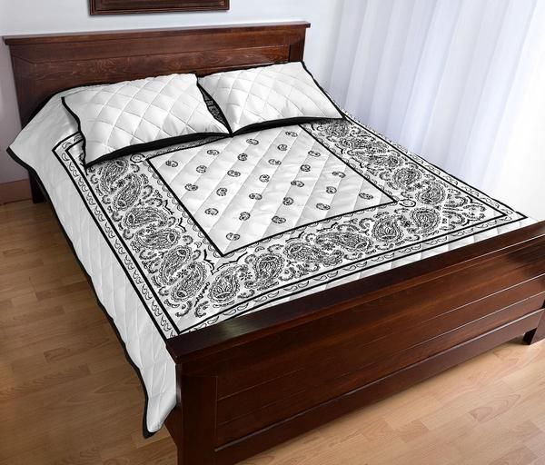 a bed with white and black bedspread on it