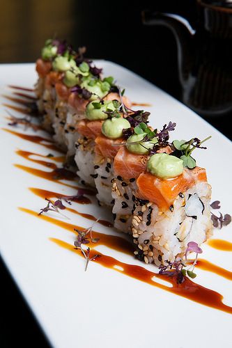 a sushi dish on a plate with sauce drizzled over it