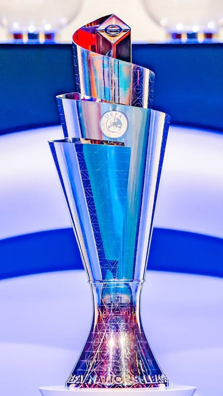 a blue glass trophy sitting on top of a white table next to a red and black object