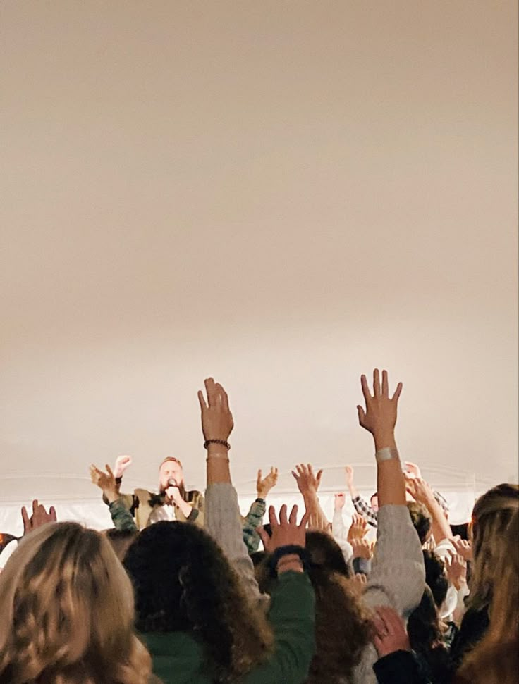 a group of people reaching their hands up in the air