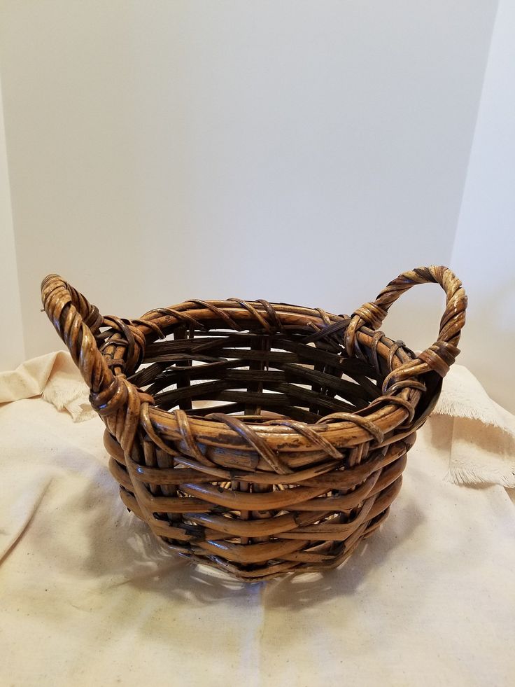 a wicker basket sitting on top of a white cloth