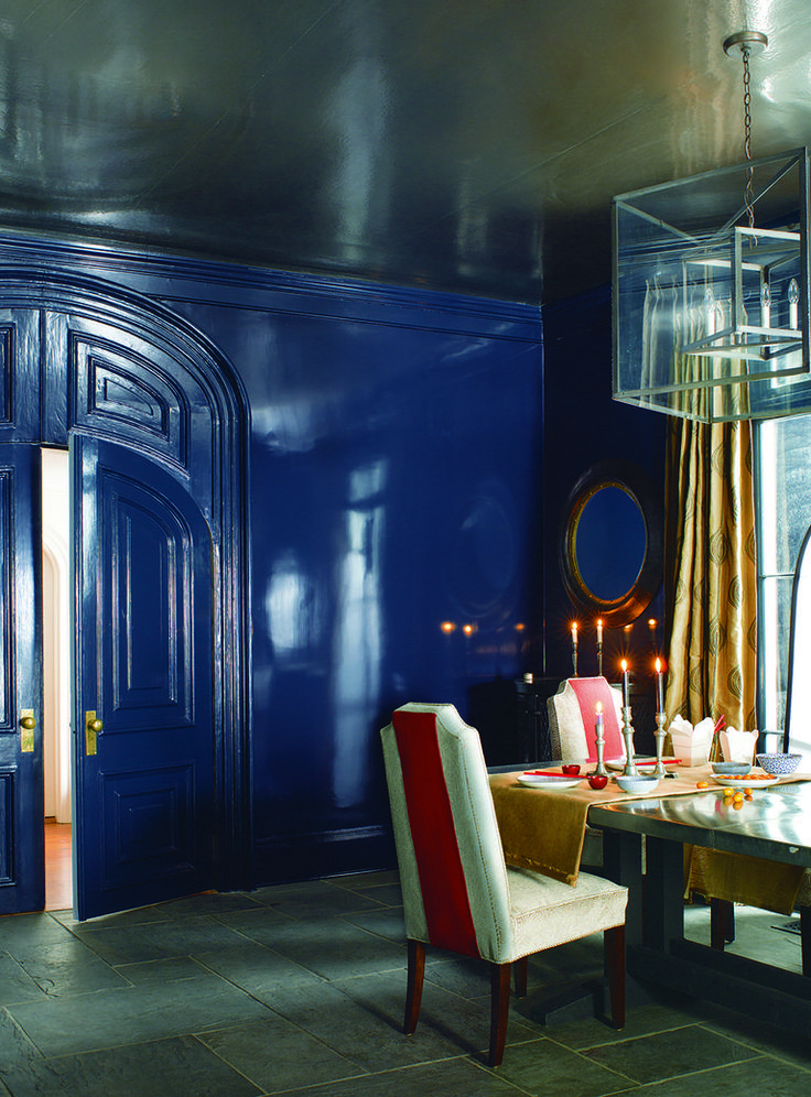 a dining room with blue walls and white chairs