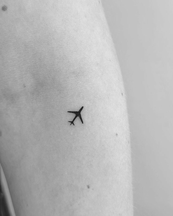 a small airplane tattoo on the right arm and lower arm, it looks like an airplane is flying in the sky