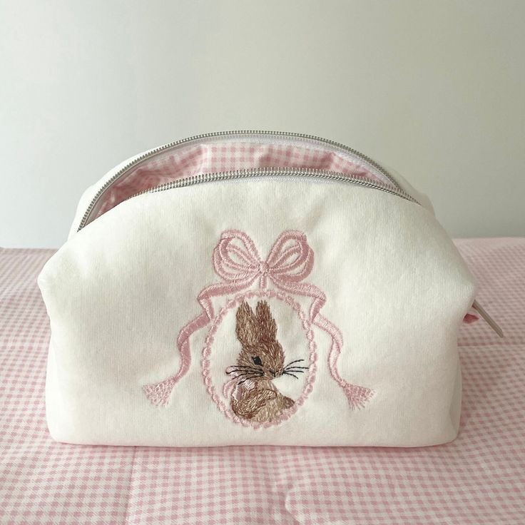 Finished Bunny and Bow Embroidered Makeup Bag Size: 20x10x9cm ✂️%100 cotton fabric. 🧼Washing Instructions: It can be hand washed. Please don't iron. 📦 Packaging: The products are shipped out within 1-2 working days. Makeup Bags For School, Seeing Makeup Bag, Sewed Makeup Bags, Pink Makeup Pouch, Pretty Makeup Bag, Embroidered Cosmetic Bag, Customized Makeup Bag, Cute Pink Purse, Embroidery Makeup Bag