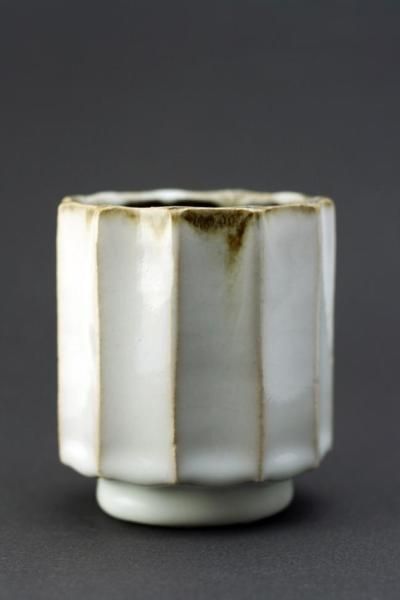 a white and gold vase sitting on top of a table