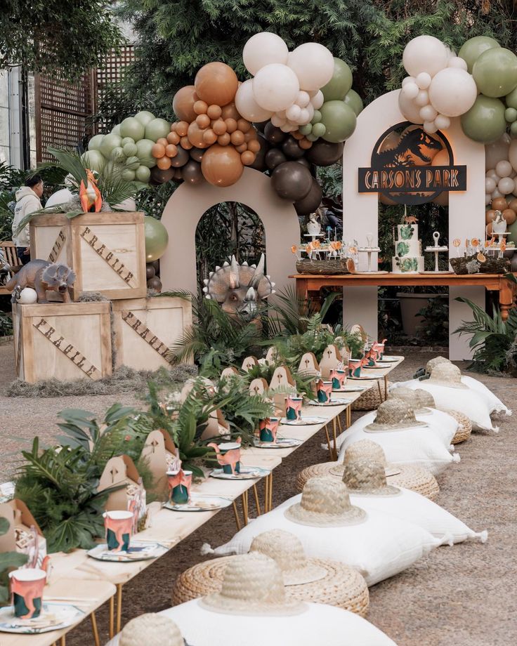 an outdoor party with balloons and hats on the tables, along with other items for decoration