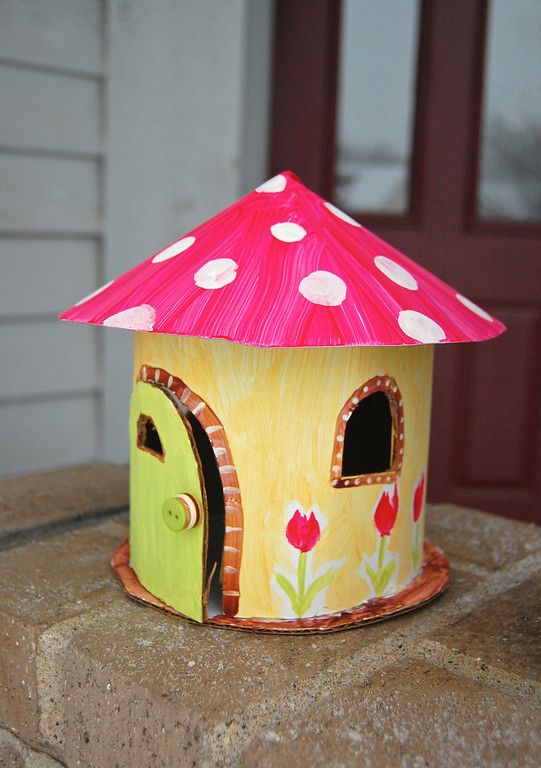 a colorful birdhouse sitting on top of a stone wall