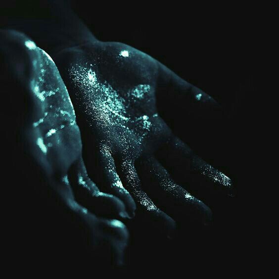 a person's hand covered in blue and white powder with their hands extended out