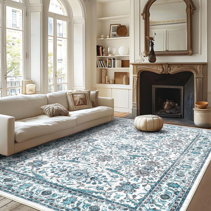 a living room filled with furniture and a large rug on top of a wooden floor